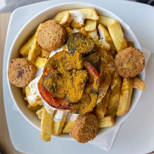 Veganes Gericht in Bunte Burger Köln: Pommes mit Falafel, orientalisches Gemüse, frischer Koriander, Aioli und Minz-Joghurt Sauce