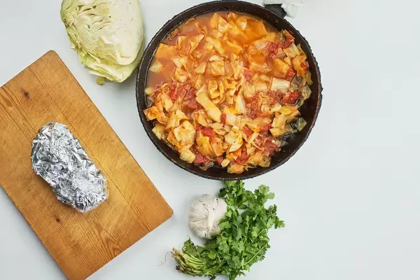 Vegetable borsch and baked chicken in foil on white