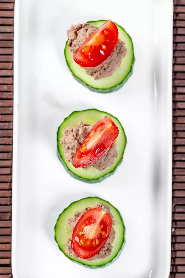Vegetable sandwiches with liver pate on a white plate. Top view