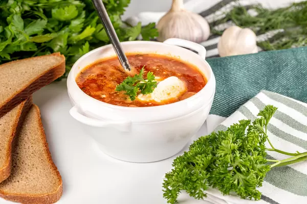 Vegetable tomato soup with sour cream and herbs
