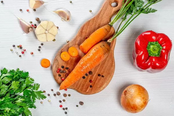 Vegetables and spices with fresh parsley on a white wooden background. Top view