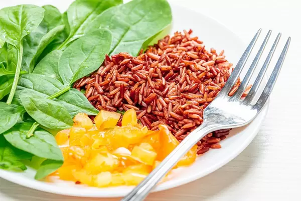 Vegetarian food-spinach, brown rice and sweet peppers on a plate with a fork close-up (Flip 2019)