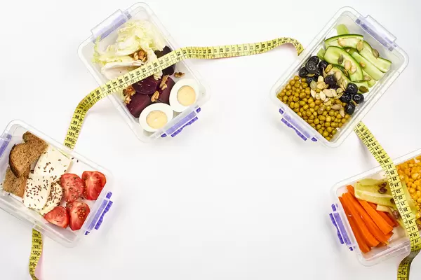 Vegetarian meals in plastic box connected with measuring tape