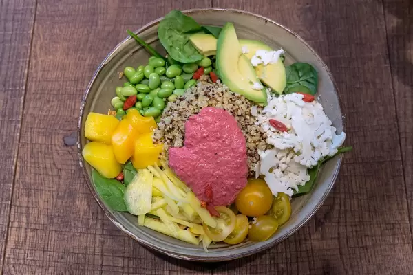 Vegetarian "Spring Time Bowl" with quinoa, yoghurt mint dressing, avocado, yellow beetroot, edamame, goji berry, baby spinach & beetroot mayo