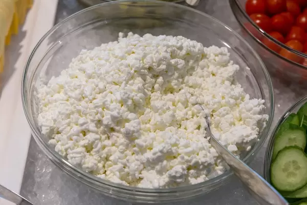 Vegetarian spread cream cheese in a glass bowl with spoon, chilled on crushed-ice at the buffet table
