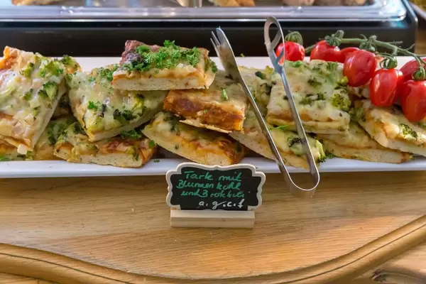 Vegetarian tart with cauliflower and broccoli on a white plate at the food buffet