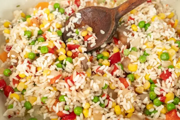 Vegetarische Ernährung: Risotto mit Erbsen, Mais, Tomaten und Paprika in Nahaufnahme
