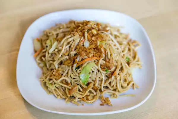 Vegetarische Mahlzeit im Restaurant mit gebratenen Nudeln, Ei und Gemüsesauce