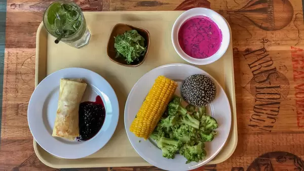 Vegetarische Mahlzeit in Russland: Crêpe mit Preiselbeersauce, gekochter Brokkoli und Mais, Swekolnik und Chuka Algensalat