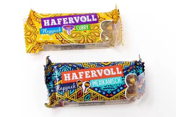 Vegetarische Müsliriegel "Hafervoll Flapjack" mit Mexikanisch & Curry - Geschmack mit kreativem Verpackungsdesign, auf weißem Untergrund