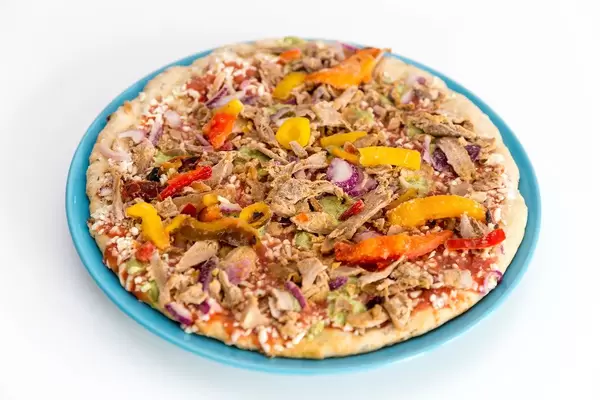 Vegetarische Protein Pizza mit Leinsamen, Quinoa und pulled Soybeans von Garden Gourmet ausgepackt gefroren auf einem Teller
