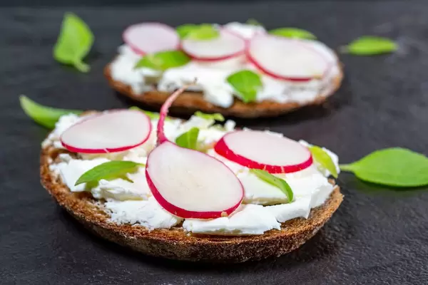 Vegetarische Sandwiches mit Frischkäse, Radieschen und Blattsalat in Nahaufnahme