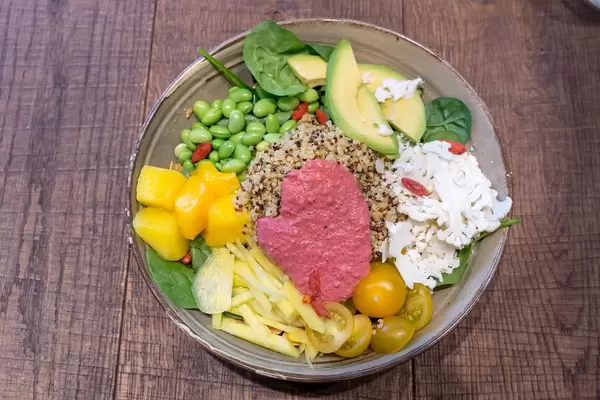 Vegetarische Spring Time Bowl mit Quinoa, Joghurt-Minz-Dressing, Avocado, gelber Beete, Edamame, Goji-Beeren, Kirschtomaten, Babyspinat, Papadam & Rote-Beete-Mayo