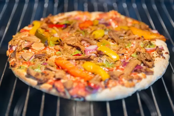 Vegetarische Tiefkühlpizza backt im Ofen auf