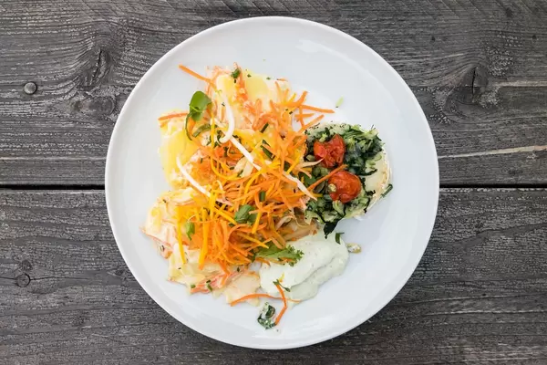 Vegetarisches Gericht: Gebackener Ziegenkäse mit Rübstiel, Kürbiskernen und geschmolzenen Tomaten dazu Möhren-Kartoffeln-Gratin und kleiner gemischter Salat