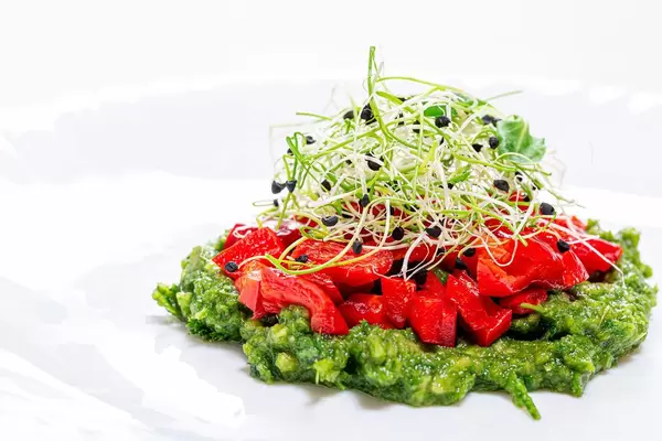 Vegetarisches, gesundes Essen: dekorativer Salat mit frischem Gemüse wie Paprika und Zwiebelkeimlingen / Sprossen