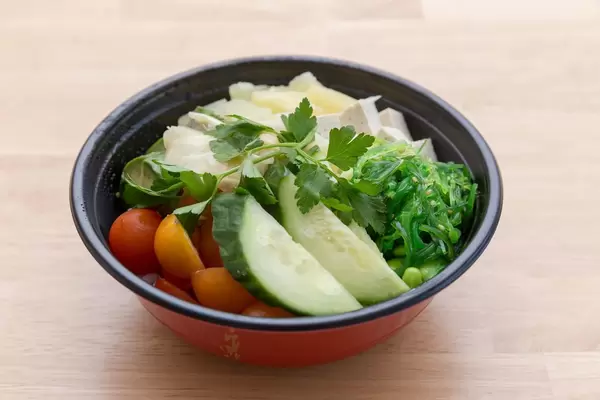 Veggie bowl salad with cucumbers, tomatoes, zucchini, pineapple, tofu and parsley