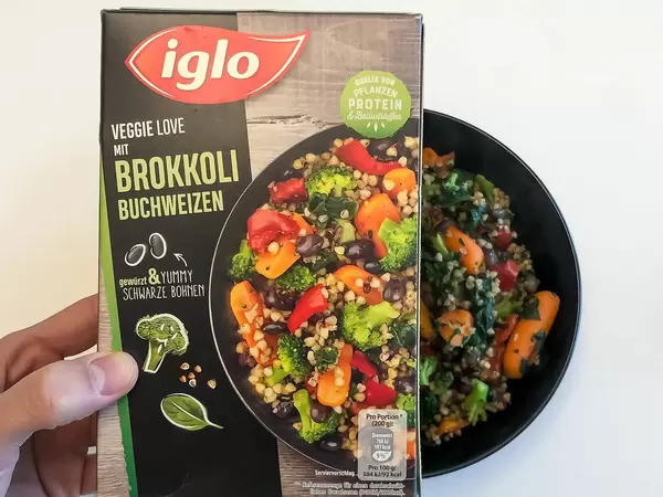Veggie Love Brokkoli-Buchweizen von Iglo: tiefgefrorenes veganes Essen in einer schwarzen Schüssel auf weißem Hintergrund