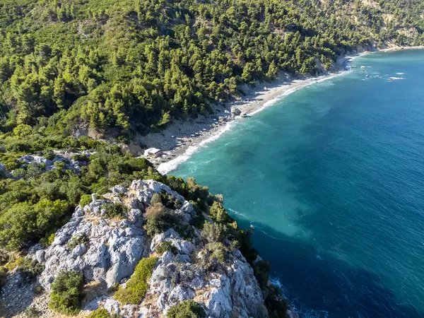Velanio Strand auf Skopelos mit dunklem Sand und türkisem Wasser. Luftbild