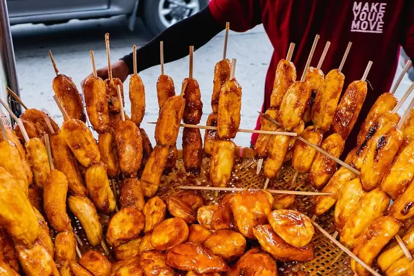 Vendor selling sugar coated bananas on a stick