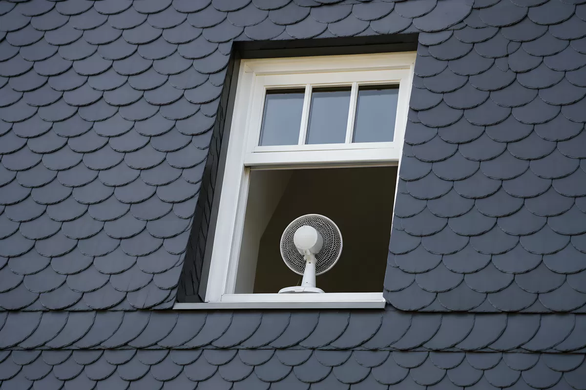 Ventilator im Dachfenster eines Schieferdachs