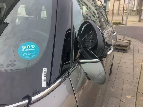 verbogener, kaputter Seitenspiegel auf der Fahrerseite eines DriveNow Autos