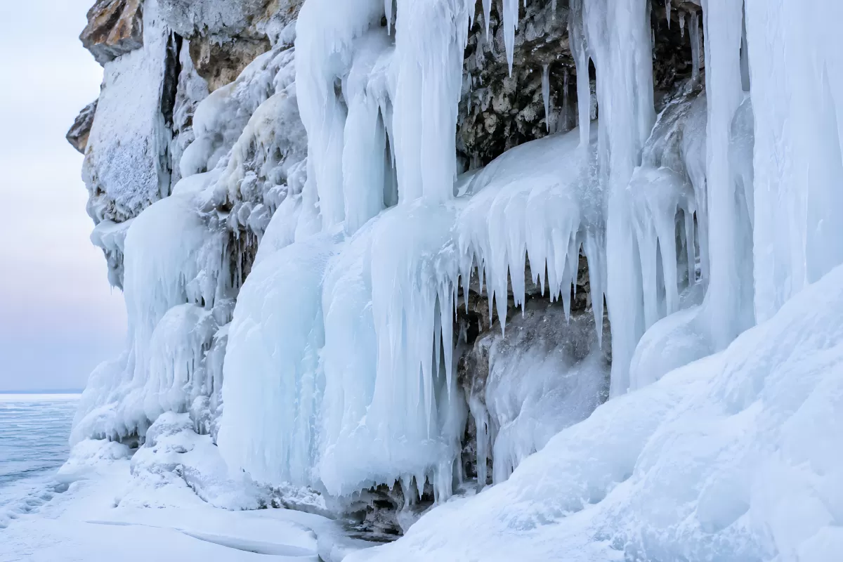Vereiste Felswand mit Eiszapfen am Winterufer