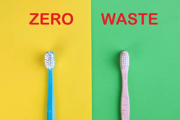 Vergleich von Zahnbürsten aus Kunststoff und Bambus, auf gelbem und grünem Hintergrund mit dem Text "Zero Waste" / Null Verschwendung