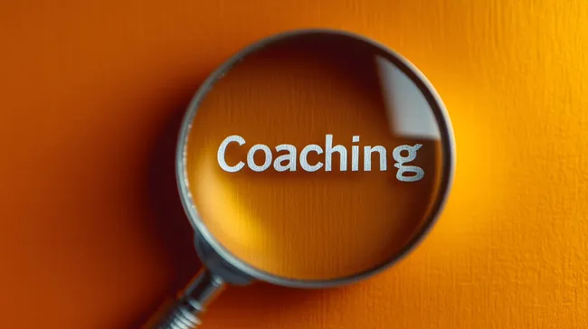 Vergrößerungsglas fokussiert auf das Wort 'Coaching'