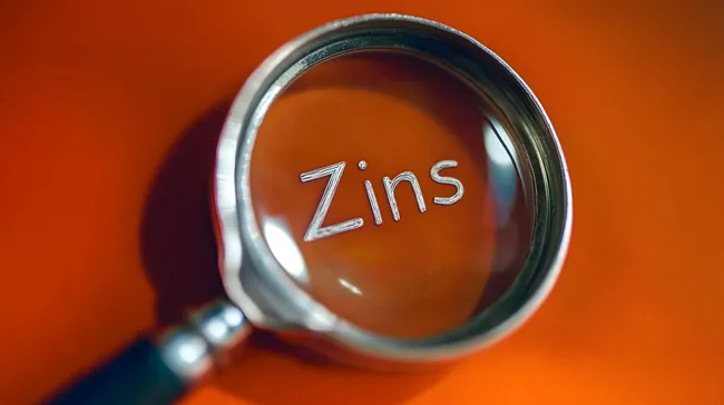 Vergrößerungsglas fokussiert auf Zinsen und Finanzen