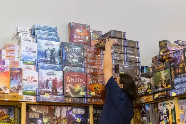 Verkäufer holt das Brettspiel Andor vom Stapel