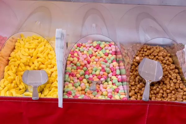 Verschiedene bunte Süßigkeiten und Zuckerwaren in Kunststoffboxen mit Schaufel