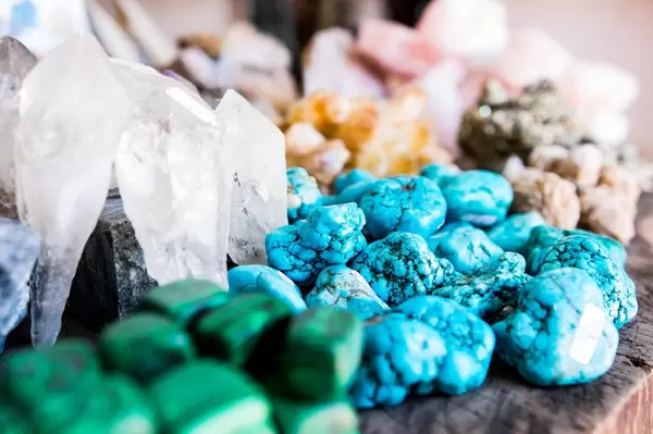 Verschiedene Edelsteine in hellblau, weiß und grün auf Holztisch