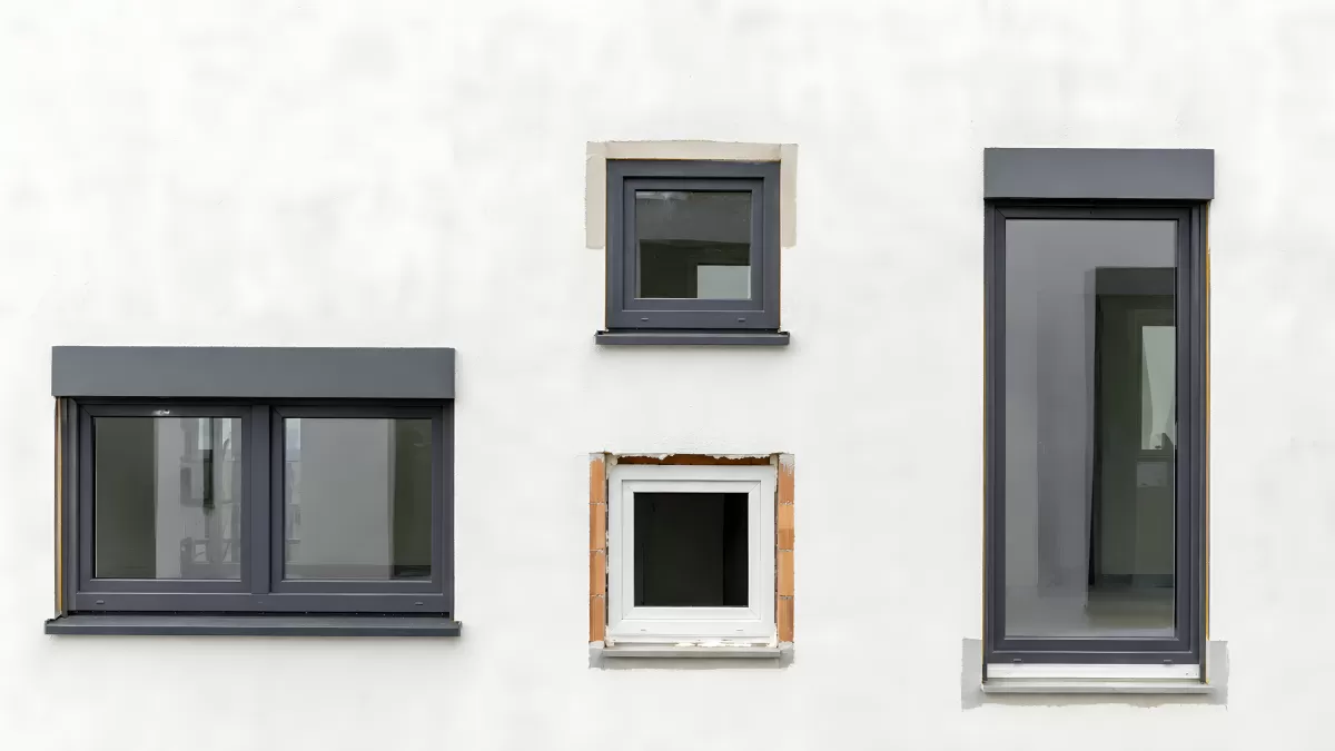 Verschiedene Fenster an weißer Hausfassade im Vergleich