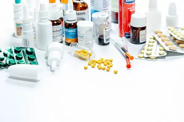 Verschiedene pharmazeutische Produkte in Fläschchen und Blistern vor weißem Hintergrund