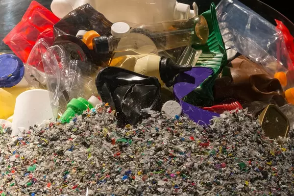 Verschiedener Plastikmüll auf Haufen von zu Plastikschnipseln verarbeitetem Müll für Recycling