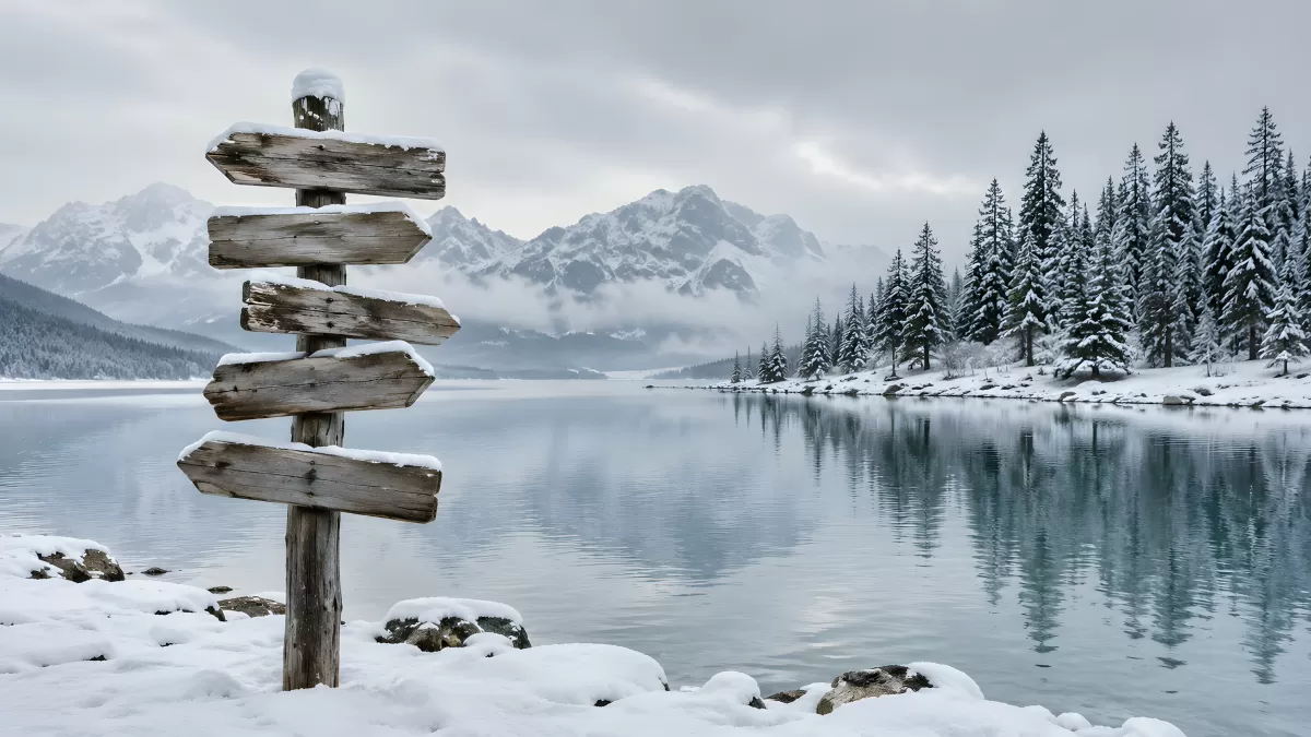 Verschneiter Wegweiser an einem stillen Bergsee