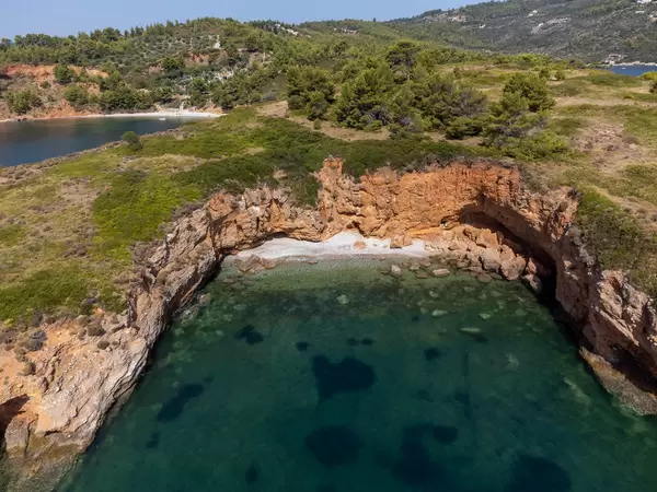 Versteckter Strand mit roten Klippen, gebildet von der Landzunge von Kokkinokastro, vom Meer aus gesehen