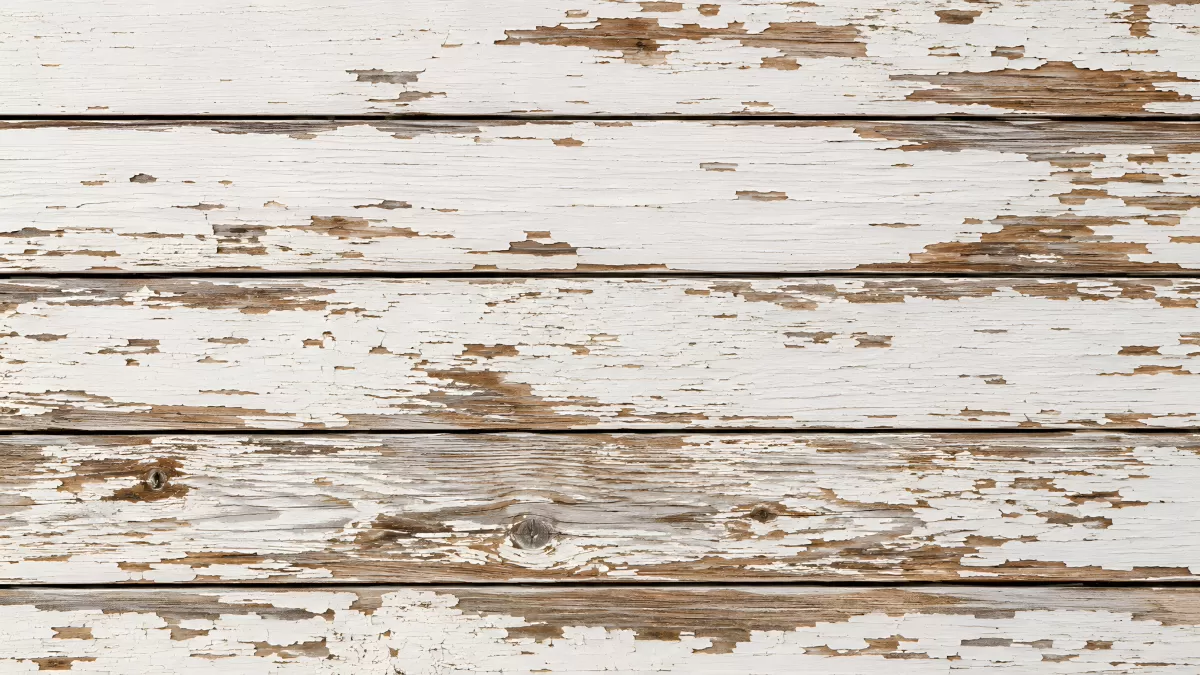 Verwitterte Holzbretter mit abblätternder weißer Farbe