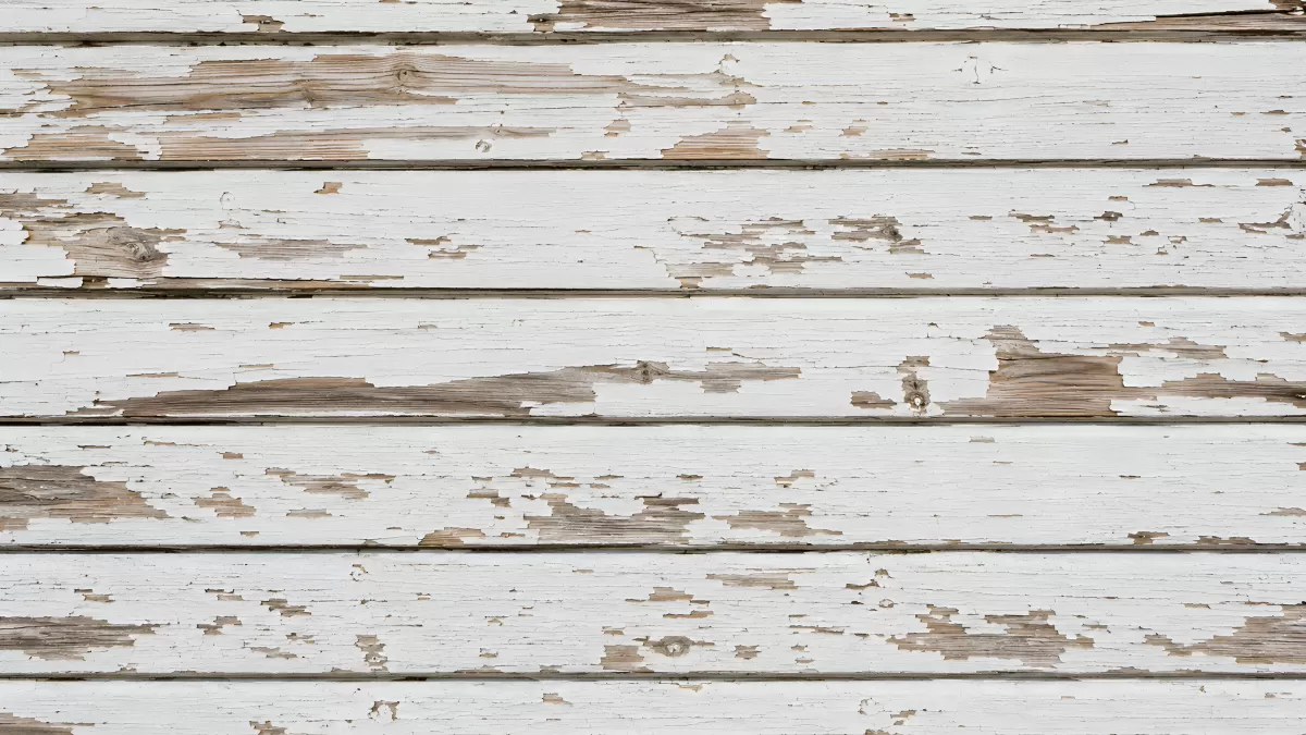 Verwitterte Holzwand mit abblätternder weißer Farbe