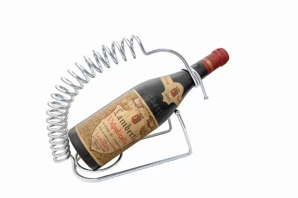 Very old bottle of red wine on white background