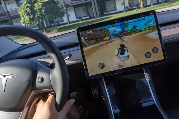 Video-Rennspiel Beach Buggy 2 auf dem Autodisplay spielbar, während der Aufladung des Tesla Model 3