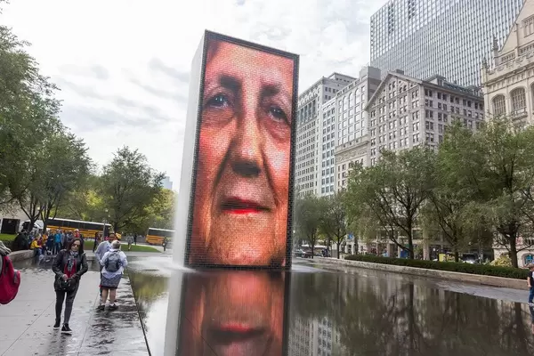 Video-Skulptur in Chicago: projiziertes Gesicht reflektiert sich auf dem schwarzem Granit der Crown Fountain im Millennium Park