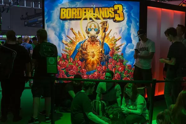 Videospielefans sitzen im grünen Licht vor dem Borderlands 3 Plakat