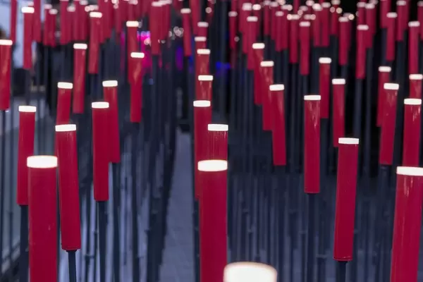 Viele Stehlampen aus roten eckigen Zylindern auf Metallstäben künstlerisch fotografiert