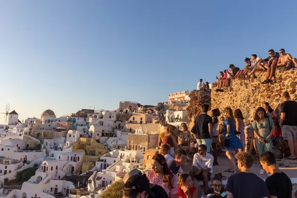 Viele Touristen besuchen am Abend den besten Fotospot für den Sonnenuntergang in Oia, Santorin