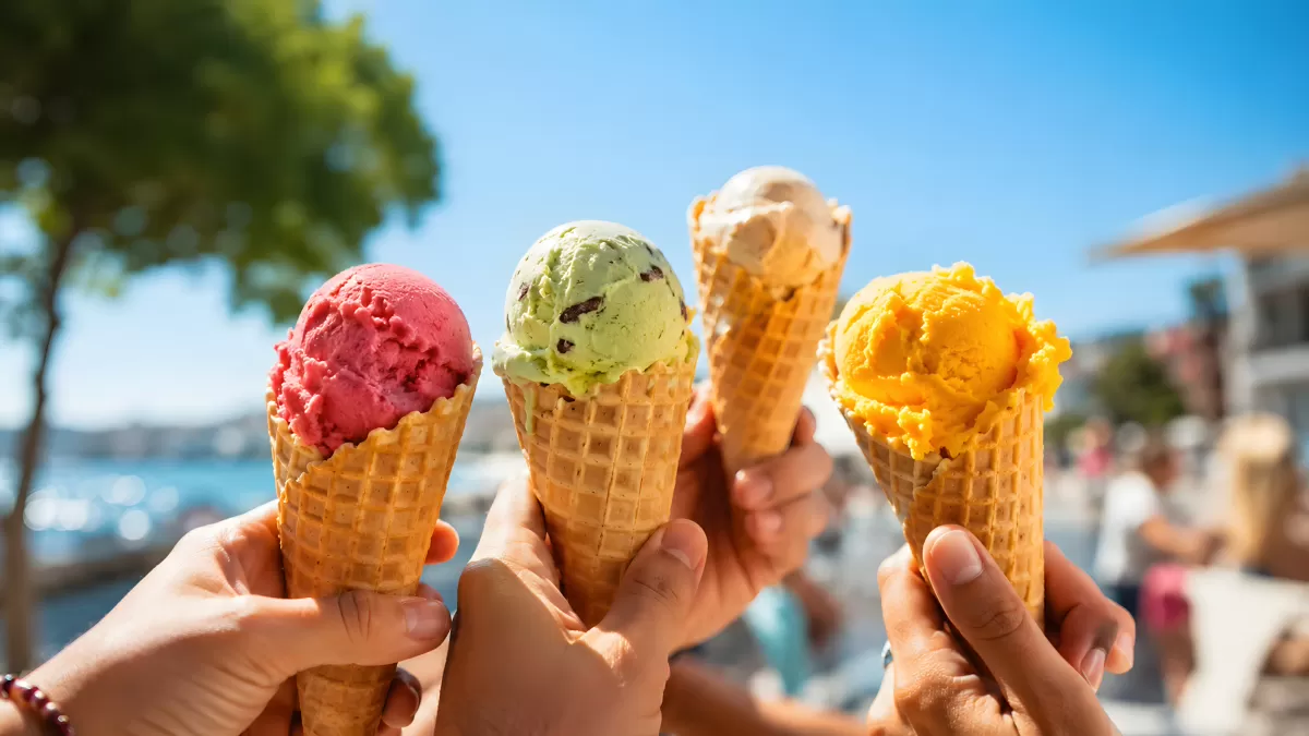 Vier bunte Eiskugeln in Waffeltüten am Sommertag