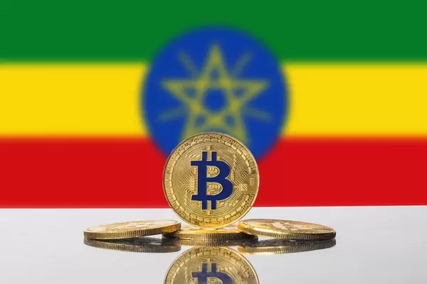 Vier goldene Bitcoins vor der bunten Flagge des Landes Äthiopien