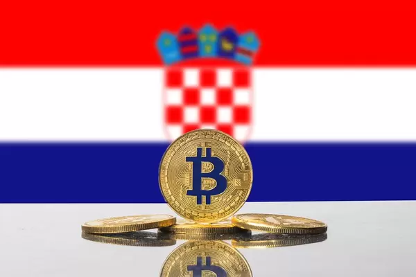 Vier goldene Münzen der Kryptowährung Bitcoin mit der Flagge Kroatiens im Hintergrund