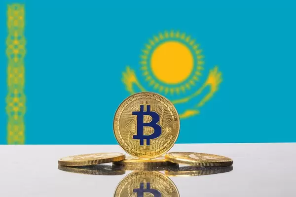 Vier goldener Bitcoins vor der Flagge von Kasachstan drapiert